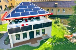 Haus mit Solarpanelen auf dem Dach und Garten, nachhaltige Energiequelle, modernes Design, umweltfreundliche Architektur.