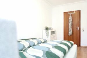 HelpMyBnB_Ferienwohnung_Dienstleistung_Koblenz Güls_Portfolio Deutschland_Koblenz Blick im Wohnzimmer auf die Couch und das Kingsize Bett