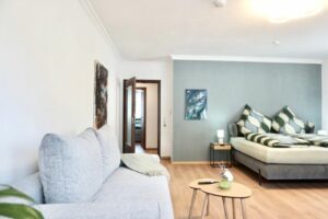 HelpMyBnB_Ferienwohnung_Koblenz Güls_Portfolio Deutschland_Koblenz Blick im Wohnzimmer auf die Couch und das Kingsize Bett