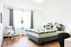 HelpMyBnB_Ferienwohnung_Koblenz Güls_Portfolio Deutschland_Koblenz_DE Blick im Wohnzimmer auf die Couch und das Kingsize Bett